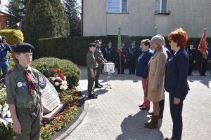 Od lewej Przewodnicząca Rady Gminy Bożenna Korlak, Wójt Maria Jolanta Batycka-Wąsik, oraz Wiceprzewodnicząca Rady Gminy Anna Lasek składają kwiaty przed pomnikiem