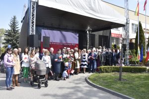 Pamiątkowe zdjęcie z uroczystości-przybyli goscie stoja przed sceną