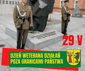 Żółty napis "Dzień Weterana Działań Poza Granicami Państwa" na zielonym tle. Herb Gminy po prawej stronie. W centralnej części obrazka stoją żołnierze przy pomniku.