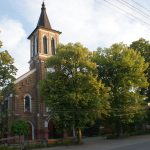 Budynek kościoła z czerwonej cegły i drzewa