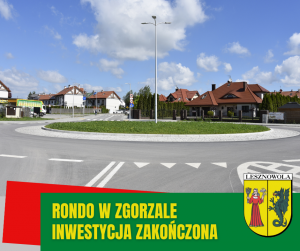 w centralnej części rondo poosnięte trawą, za rondem budynki.