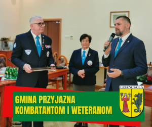 Na zdjęciu stoją trzy osoby, od lewej mężczyzna w mundurze, w środku kobieta w mundurze, po prawej mężczyzna w marynarce trzyma w dłoni mikrofon. Na dole na zielonym pasku napis: Gmina przyjazna kombatantom i weteranom. W prawym dolnym rogu herb gminy.