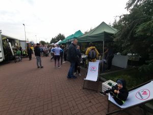 Na obrazku znajduje się dużo osób i stoisk.