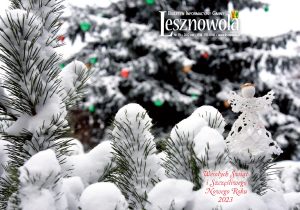 Ośnieżone krzewy i choinka w tle. na dole napis czerwoną czcionka Wesołych Świąt i Szczęśliwego Nowego roku 2023