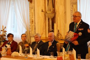 Oficer przemawia za stołem prezydencjalnym.