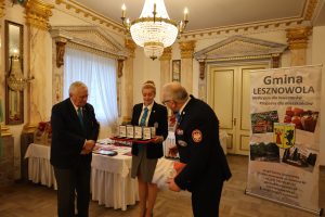 Dwóch mężczyzn i kobieta, która trzyma medale.