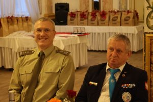 Dwóch mężczyzn siedzi za stołem.