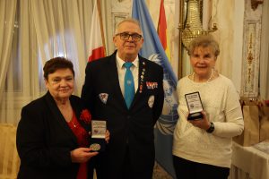 Mężczyzna i dwie panie, które prezentują medale.