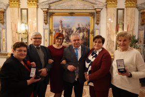 Cztery kobiety i dwóch mężczyzn we wspólnym zdjęciu z medalami.