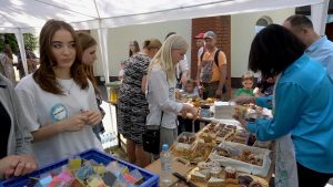 Ludzie stoją przy stoiskach gastronomicznych.