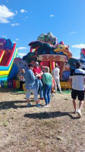 Ludzie stoją przed dmuchańcami.