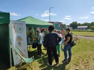 Osoby stoją przy stoisku Gminnej Biblioteki Publicznej w Lesznowoli