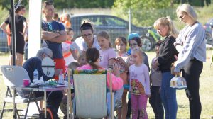 Dzieci czekają w kolejce do malowania buziek.