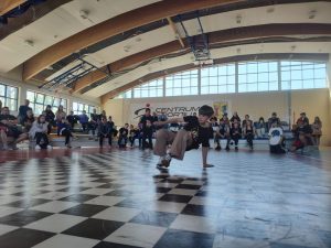 Chłopiec tańczy na podłodze w kolorach szachownicy.