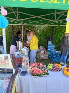Cztery kobiety stoją na stoisku z jedzeniem.