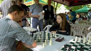 Mężczyzna gra z młodą dziewczyną w szachy.