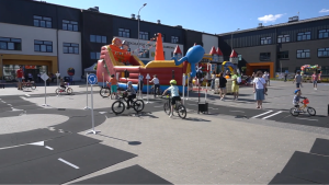 Dzieci jeżdżą rowerami po miasteczku ruchu drogowego.