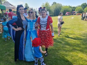 Trzy kobiety w przebraniach (2 księżniczki i Myszka Mini) stoją i pozują do zdjęcia.