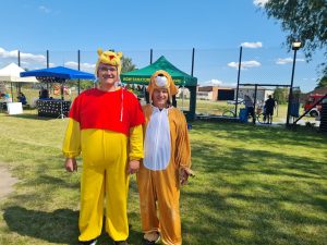 Dwóch mężczyzn w przebraniu Kubusia Puchatka i Psa Pluto pozują do zdjęcia.