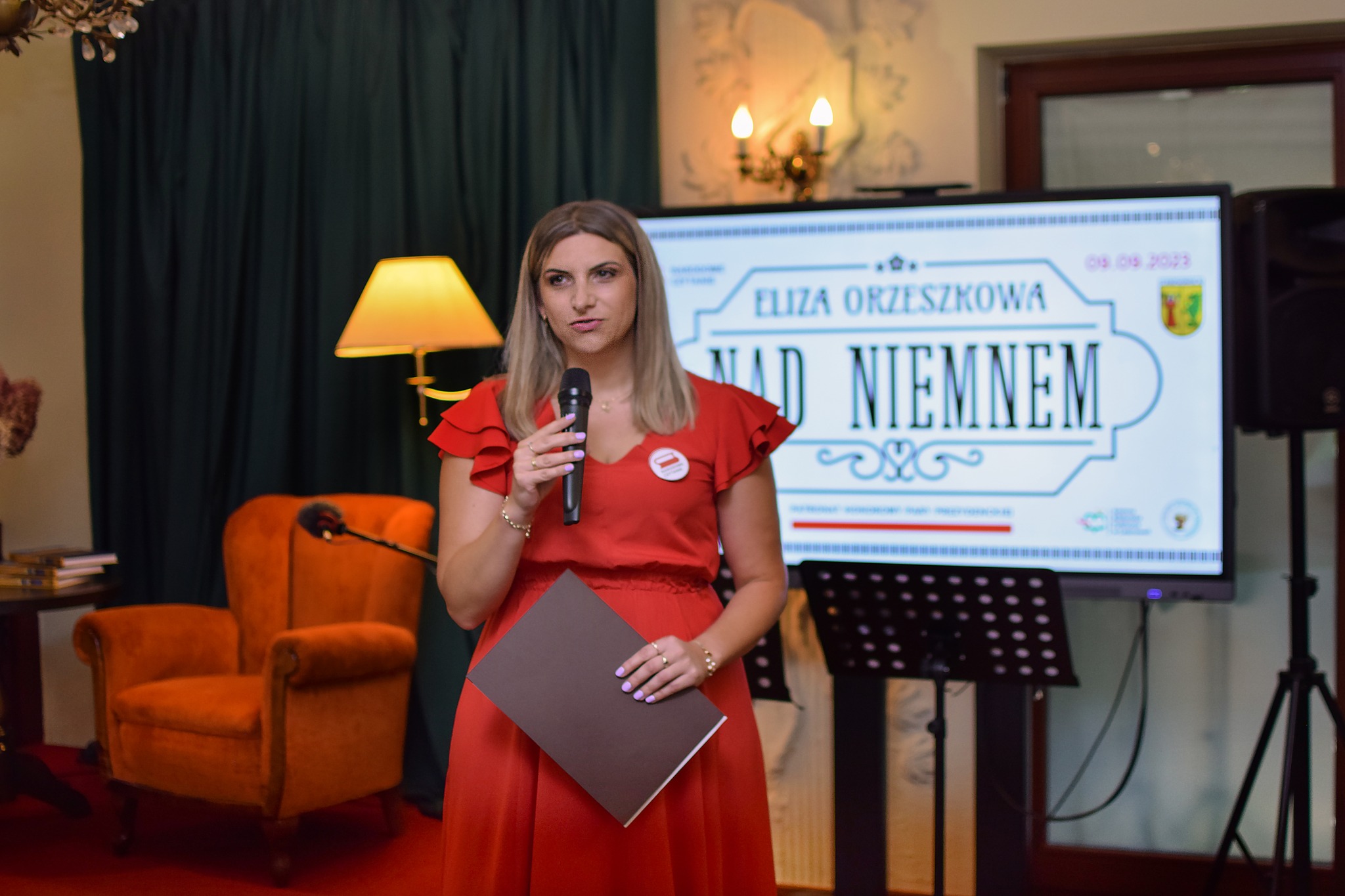 Kobieta wita przybyłych gości.