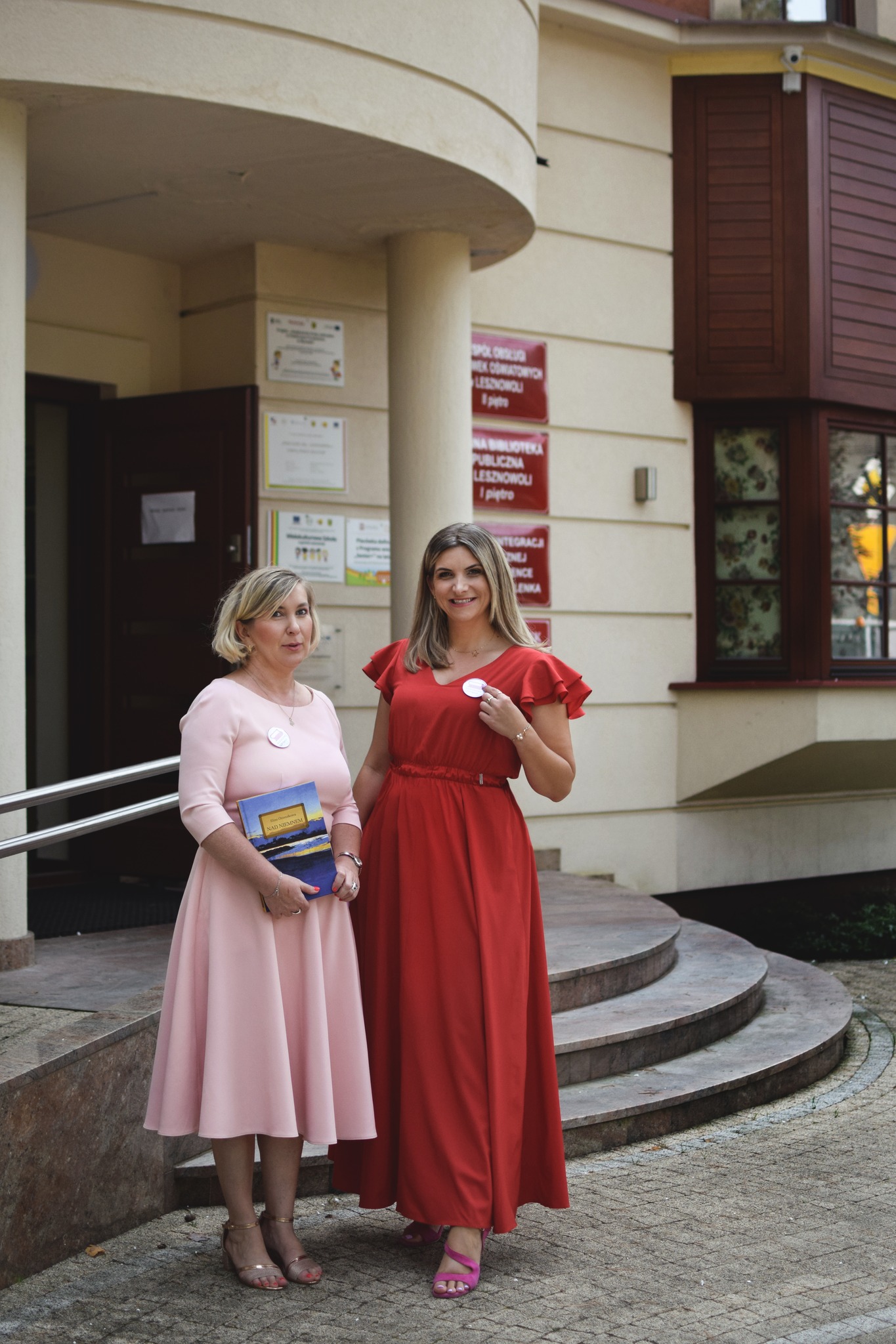 Dwie kobiety stoją przed budynkiem.