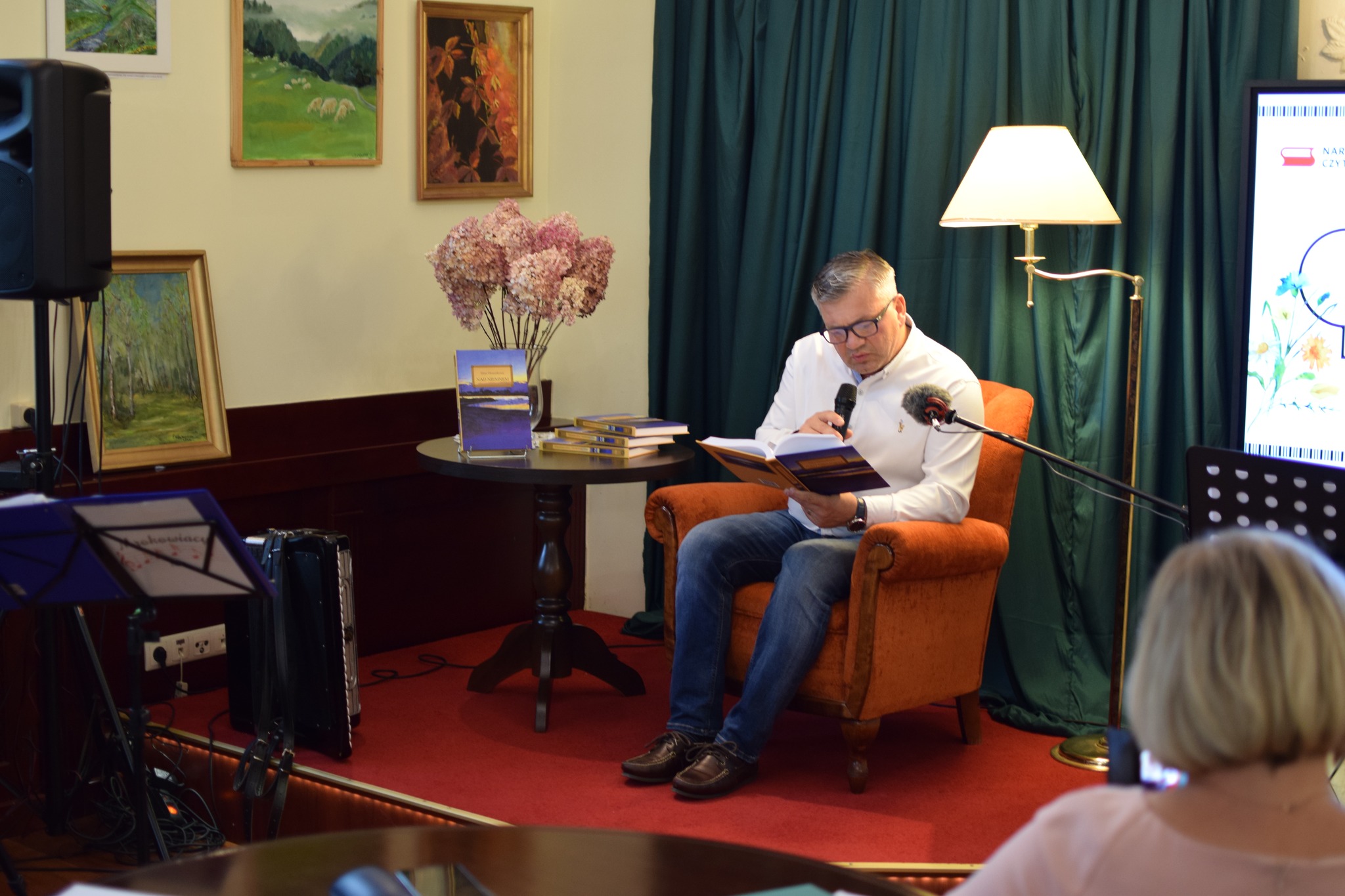 Zastępca Wójta Gminy Lesznowola siedzi na fotelu i czyta "Nad Niemnem".