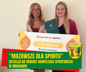 Od lewej Wójt Maria Jolanta Batycka-Wąsik i Skarbnik Marta Sulimowicz z tablicą informującą o dotacji na remont kompleksu sportowego w Mrokowie.