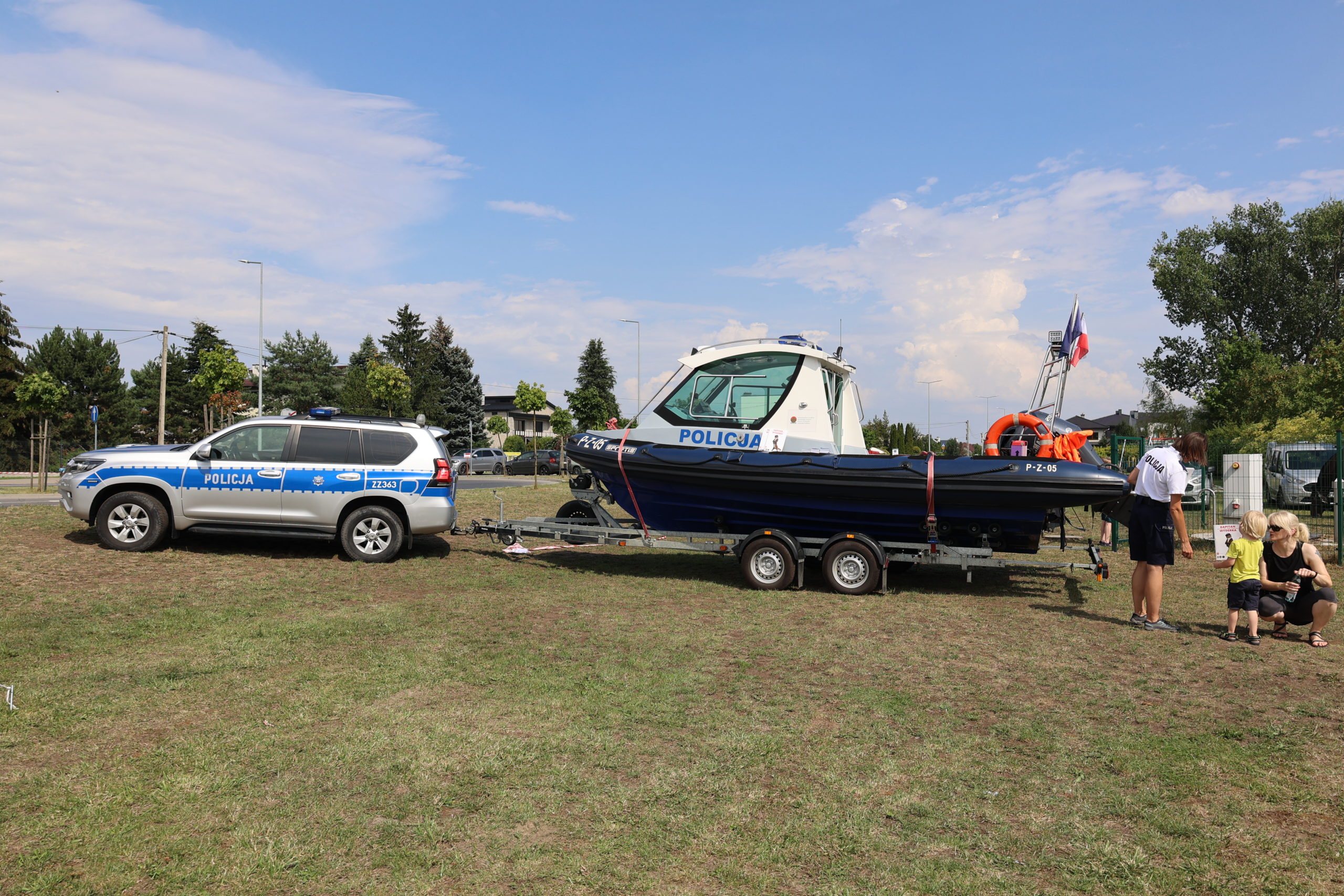 Samochód z podpiętą przyczepką, na której jest motorówka