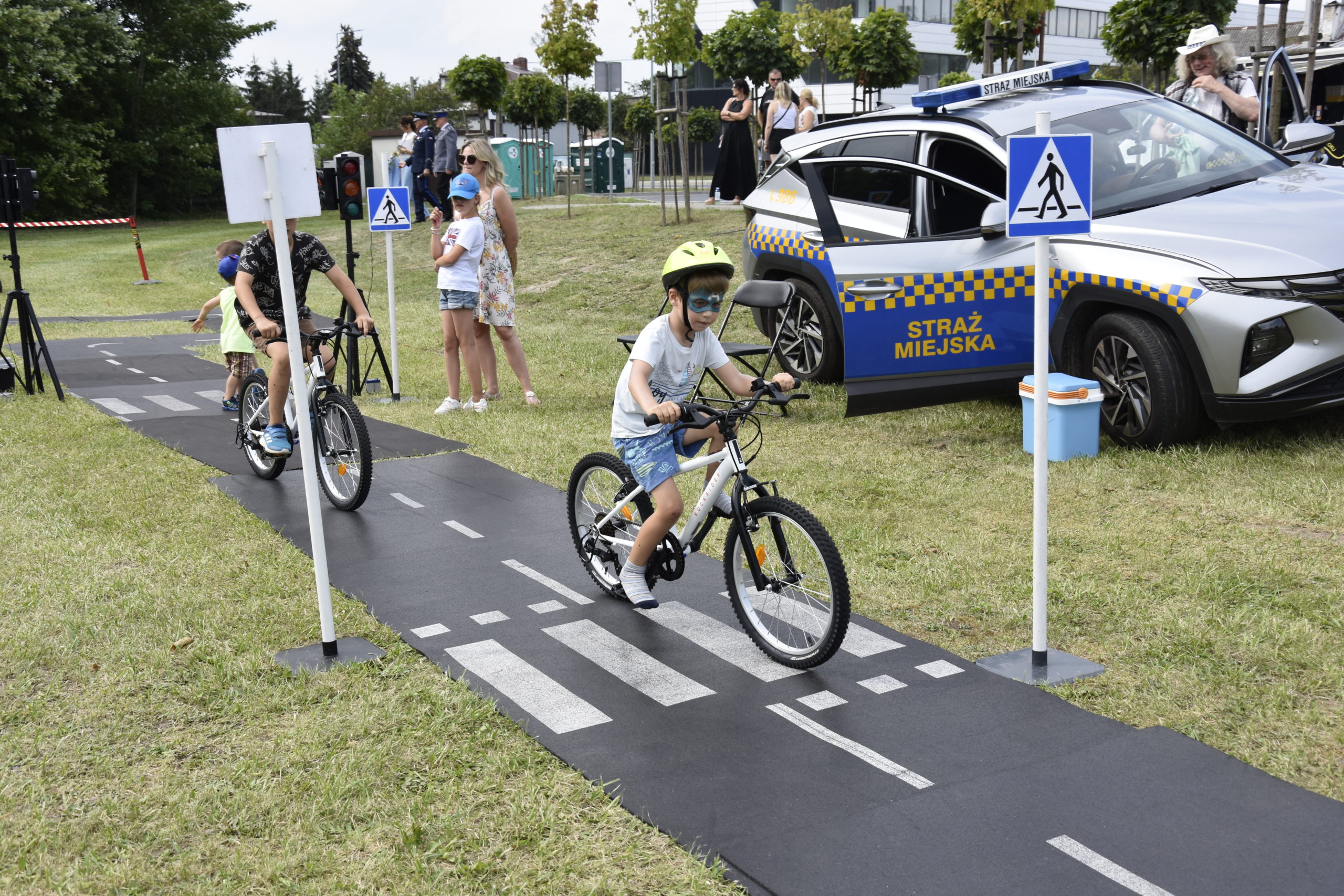 Chłopcy na rowerach jeżdżą po ścieżkach Straży Miejskiej