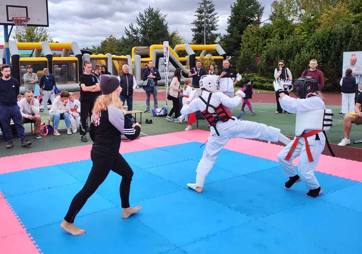 Zawodnicy w specjalnych strojach walczą na macie.