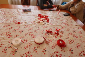 Stół ze wstążkami, widoczne ręce kobiet