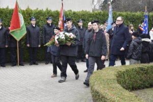 Dwaj mężczyźni i kobieta oraz harcerze z wieńcem. Poczty sztandarowe