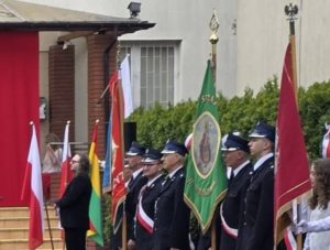 Na obrazku widać postacie strażaków uczestniczące w obchodach 3 Maja