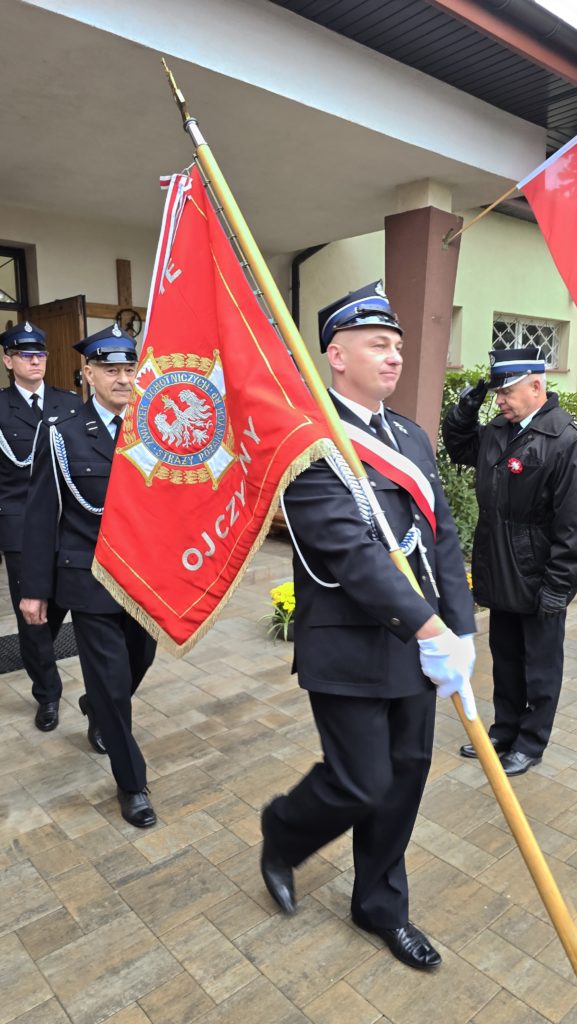 Strażak ze sztandarem wychodzący z kościoła